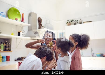 Junge Familie, die mit Spielzeug-Dinosauriern spielt Stockfoto