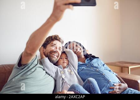 Glückliche schwangere junge Familie, die selfie nimmt Stockfoto