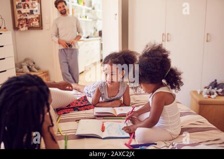 Junge Familie färbt sich auf dem Bett Stockfoto