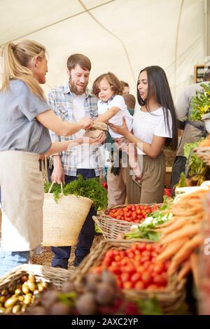 Junge Familie kauft auf dem Bauernmarkt Stockfoto