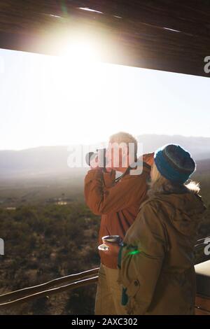 Älteres Paar mit Kamera auf sonnigen Safari-Balkon Stockfoto