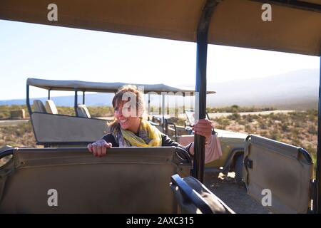 Glückliche Frau, die in ein Geländefahrzeug mit Safari kommt Stockfoto