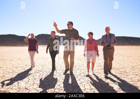 Safari Tour Guide führende Gruppe in der sonnigen ariden Wüste Südafrika Stockfoto