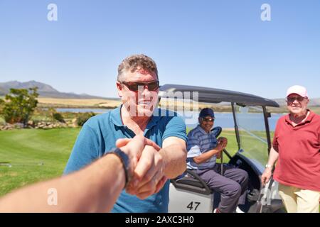 Persönliche Perspektive männliche Golfer, die auf einem sonnigen Golfplatz hanteln Stockfoto