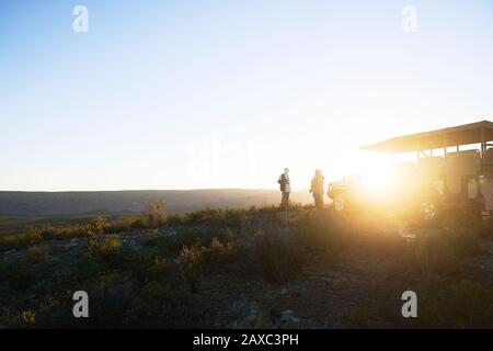 Safari Tour Gruppe auf sonnigen Hügel bei Sonnenaufgang Südafrika Stockfoto