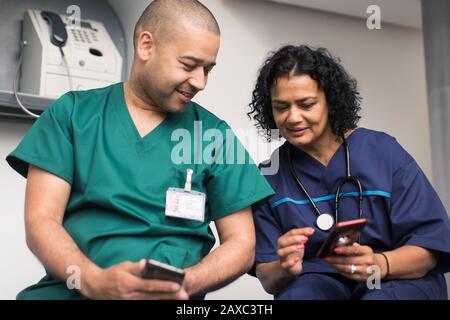 Arzt und Chirurg mit Smartphones Stockfoto