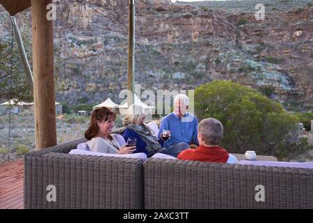 Ältere Freunde entspannen sich mit Wein auf der Hotelterrasse Stockfoto