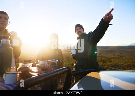 Safari-Tour-Guide und Gruppengespräch und Teetrinken bei Sonnenaufgang Stockfoto