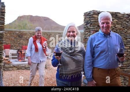 Portrait fröhliches älteres Paar, das Wein auf der Hotelterrasse trinkt Stockfoto