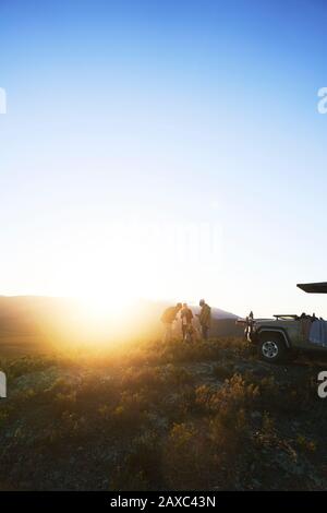 Safari Tour Gruppe auf sonnigen Hügel bei Sonnenaufgang Südafrika Stockfoto