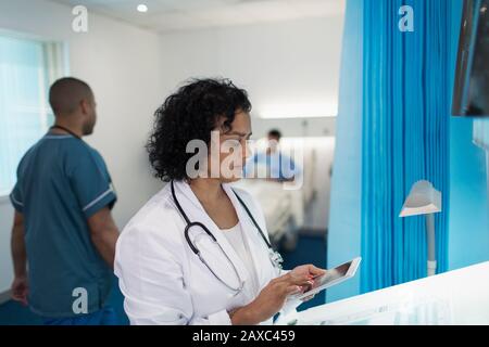 Ärztin mit digitaler Tablette im Krankenhauszimmer Stockfoto