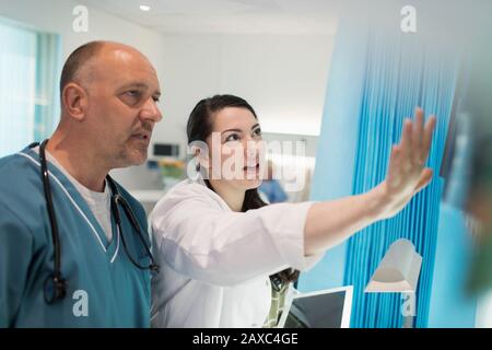 Ärzte diskutieren Röntgenaufnahmen im Krankenzimmer Stockfoto