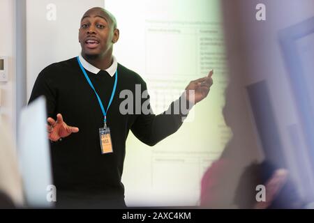 Führungsstunde des männlichen Dozenten auf der Projektionsleinwand im Klassenzimmer Stockfoto