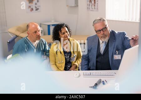 Ärzte und Administrator treffen sich am Computer im Arztbüro Stockfoto