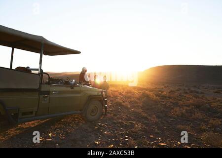 Safari Tour Group beobachtet Sonnenuntergang mit Geländewagen Südafrika Stockfoto