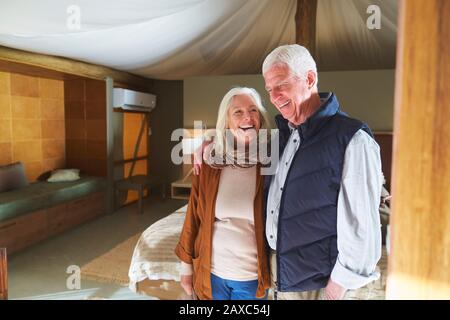 Glückliches älteres Paar lacht im Hotelzimmer Stockfoto