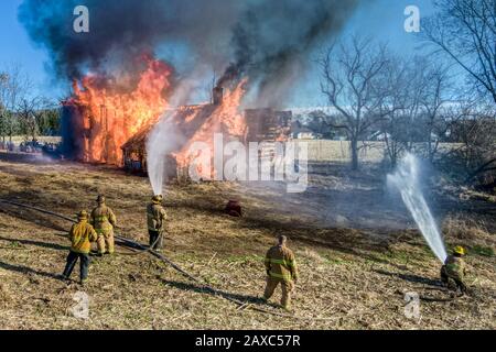 Feuerwehrleute im Einsatz, die Feuer auf brennendes Zuhause bekämpfen, amerikanische Helden Stockfoto