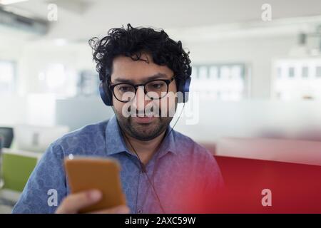 Mit Kopfhörern und mp3-Player hören Geschäftsleute Musik Stockfoto