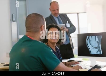 Krankenschwestern diskutieren über digitales Röntgen am Computer im Arztbüro Stockfoto