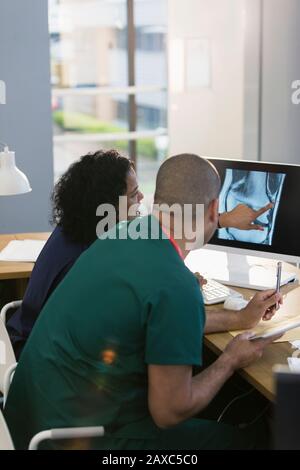 Krankenschwestern diskutieren über digitales Röntgen am Computer in der Klinik Stockfoto