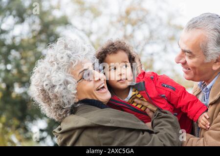 Zärtliche Großeltern umarmen Enkel Stockfoto