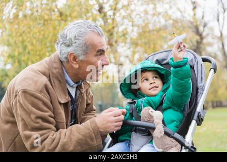 Großvater mit neugierigem Enkel im Kinderwagen Stockfoto