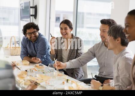 Fröhliche Geschäftsleute genießen Sushi-Mittagessen Stockfoto