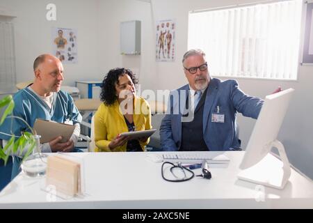 Ärzte und Administrator treffen sich am Computer im Arztbüro Stockfoto