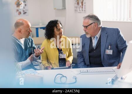 Ärzte und Administrator treffen sich am Computer im Arztbüro Stockfoto