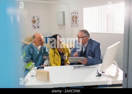 Ärzte und Administrator treffen sich am Computer im Arztbüro Stockfoto