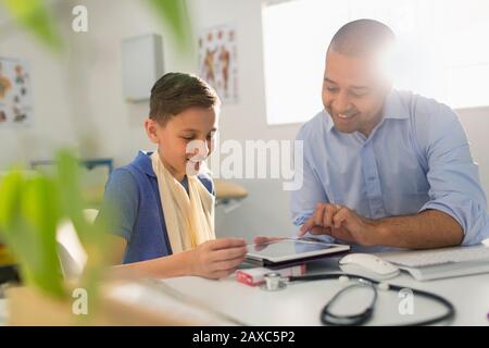 Ein Kinderarzt zeigt digitale Tablette für junge Patienten im Arztbüro Stockfoto