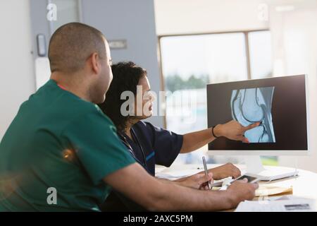 Krankenschwestern diskutieren über digitales Röntgen am Computer in der Klinik Stockfoto