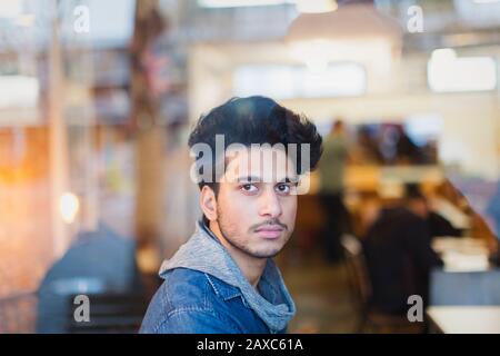 Portrait selbstbewusster junger Mann im Café-Fenster Stockfoto