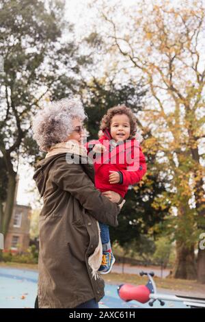 Großmutter mit Enkel auf dem Herbstspielplatz Stockfoto