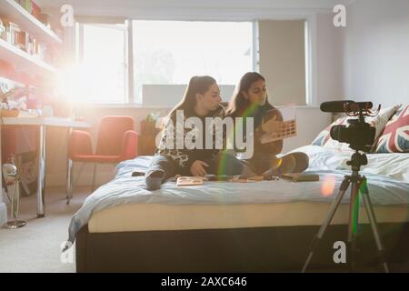 Teenager-Mädchen schwungeln über Make-up im Bett im sonnigen Schlafzimmer Stockfoto