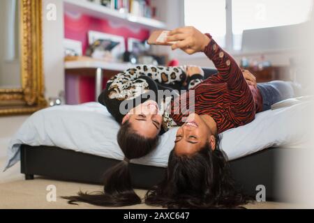 Glückliche Teenager-Mädchen, die selfie auf den Kopf gestellt haben Stockfoto