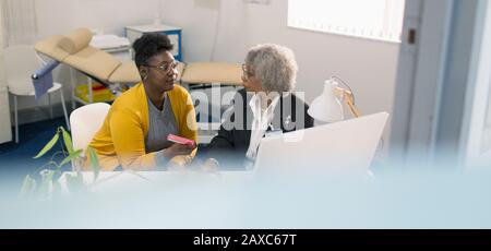 Ärztin diskutiert Medikation mit Patient in der Arztpraxis Stockfoto