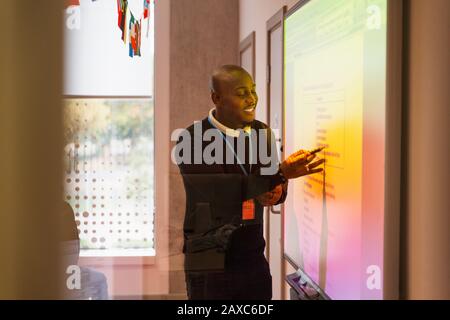 Führungsstunde des männlichen Dozenten auf der Projektionsleinwand im Klassenzimmer Stockfoto