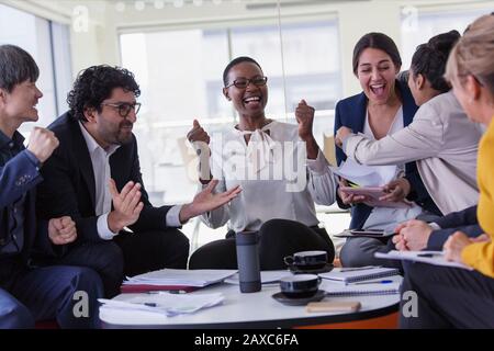 Aufgeregte Geschäftsleute jubeln in Meetings Stockfoto