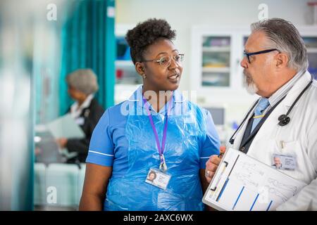 Männliche Ärztin und Krankenschwester sprechen im Krankenhaus Stockfoto