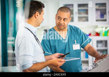 Männlicher Arzt und Krankenschwester sprechen im Krankenhaus Stockfoto