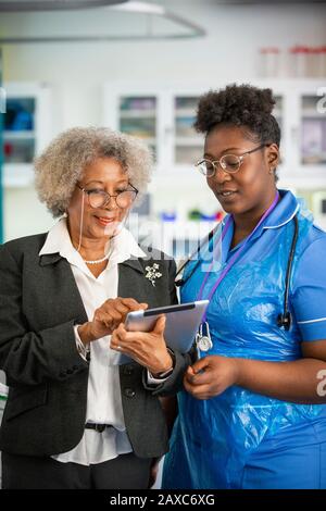 Ärztin und Krankenschwester mit digitaler Tablette in der Klinik Stockfoto