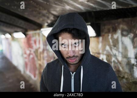 Porträt bedrohlicher junger Mann im städtischen Tunnel Stockfoto