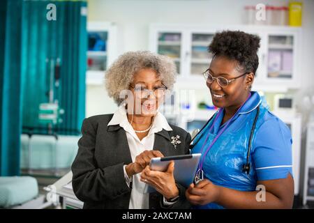 Ärztin und Krankenschwester mit digitaler Tablette im Krankenhaus Stockfoto