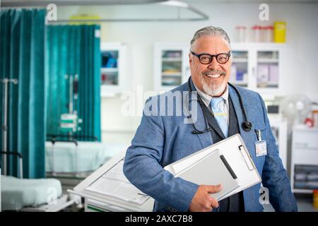 Portrait selbstbewusster leitender männlicher Arzt macht im Krankenhaus Runde Stockfoto