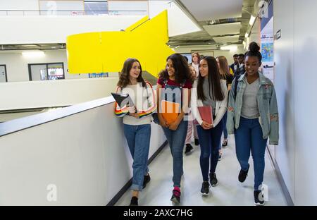 Schüler der jungen hohen Mädchen, die auf dem Flur spazieren Stockfoto