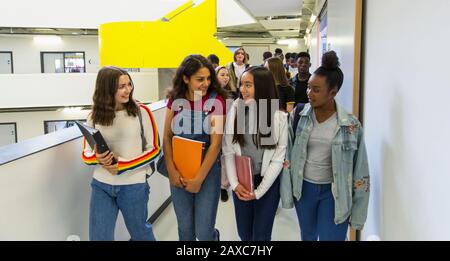 Schüler der jungen hohen Mädchen, die auf dem Flur spazieren Stockfoto