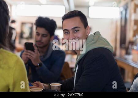 Portrait selbstbewusster junger Mann, der mit Freunden im Café aufhängt Stockfoto