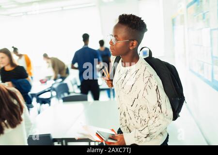 Schüler des High-School-Jungen mit Rucksack verlässt das Klassenzimmer Stockfoto