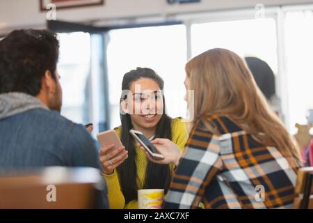 Junge Freunde, die Smartphones im Café nutzen Stockfoto